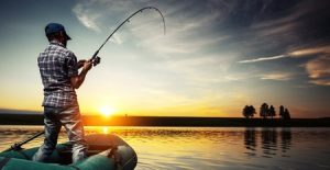 Mature man fishing from the boat on the pond at sunset Stoned Driving